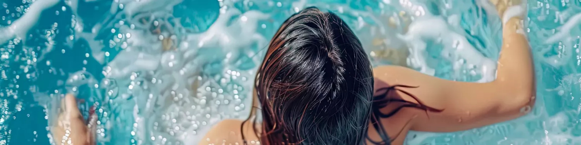 Oxygen spas : Image d'un jacuzzi en fonctionnement sur un balcon, où on peut voir en arrière-plan à gauche des chaises en bois.