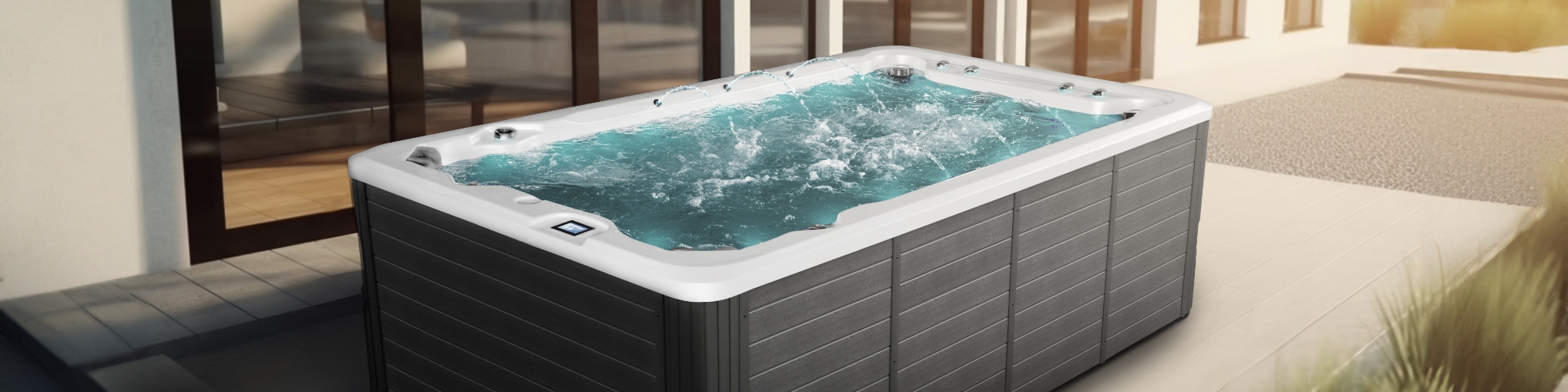 Oxygen Spas : Image d'un jacuzzi en fonctionnement sur un balcon, où on peut voir en arrière-plan à gauche des chaises en bois.